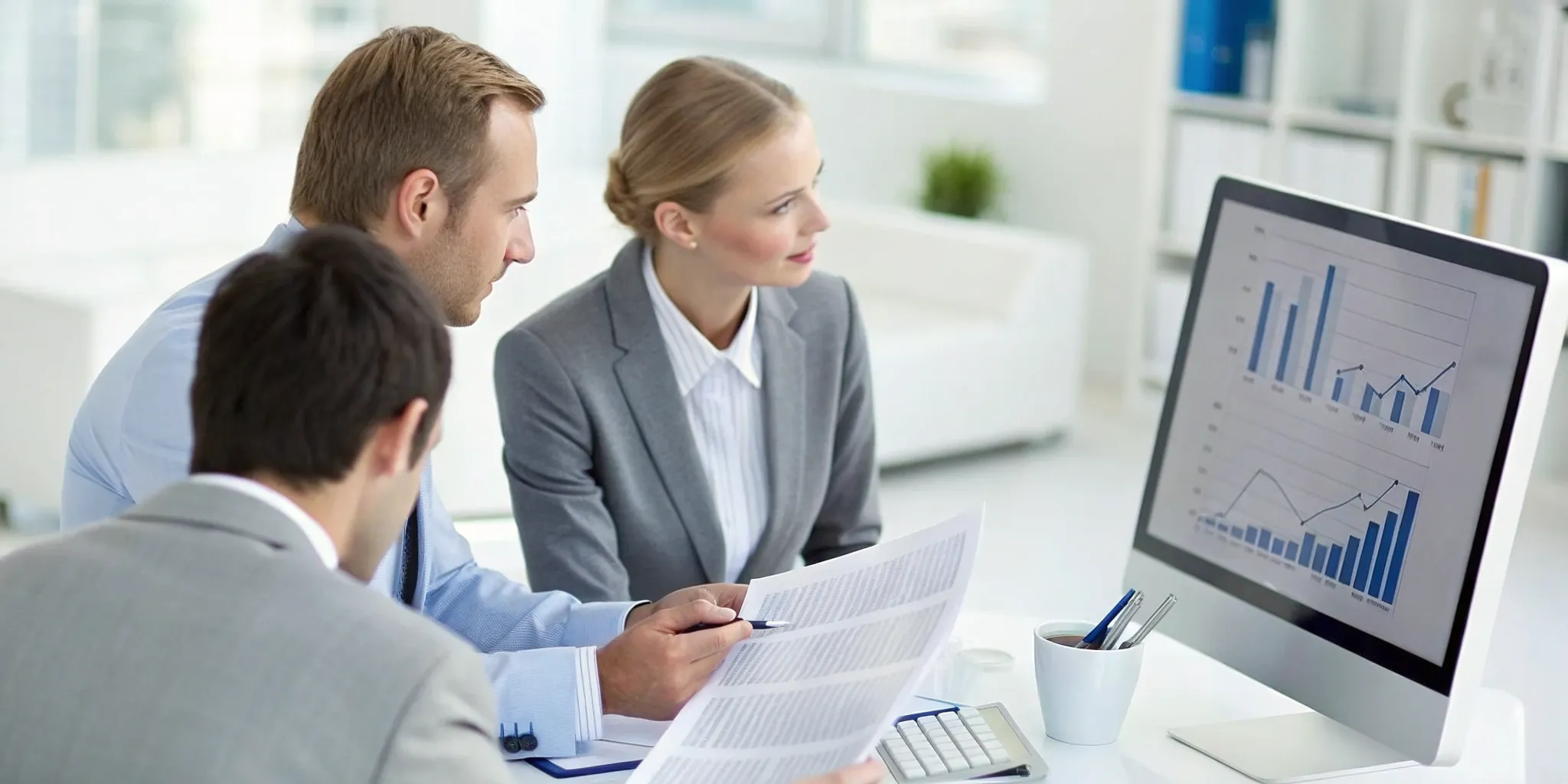 A team reviewing financial documents on a laptop to select a 1031 exchange group.