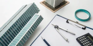 Architectural models and a calculator on a desk for a 1031 exchange tax strategy.