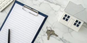 A clipboard with a real estate tax planning checklist next to a house model and keys.